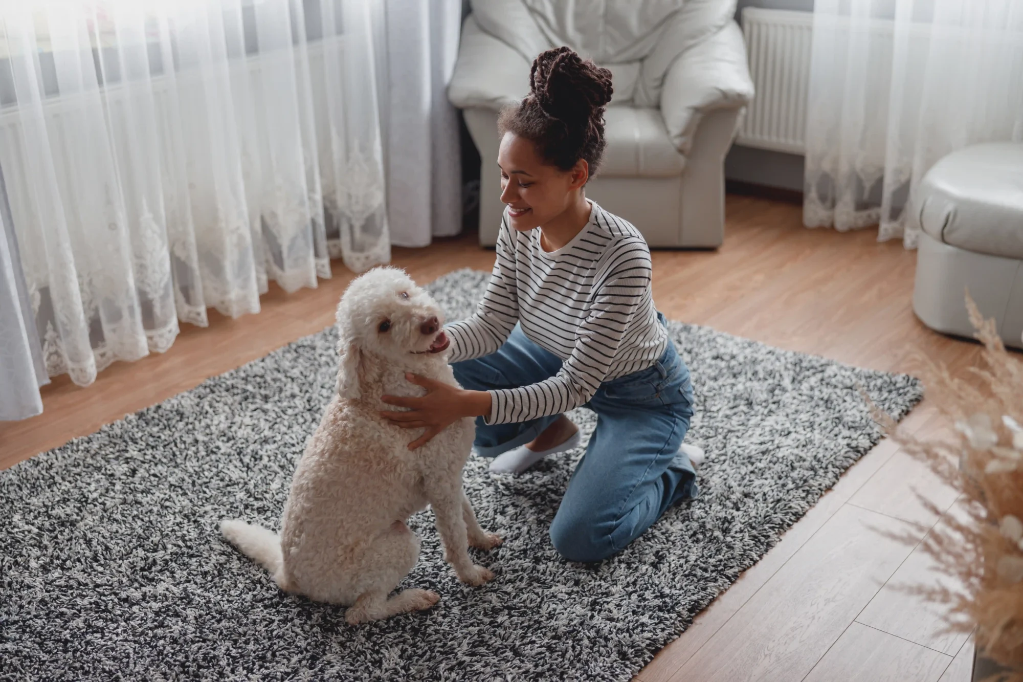 Woman smiling and playing with a dog